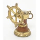 A gilt metal pendant charm formed as a ship's wheel and stylised binnacle set with miniature