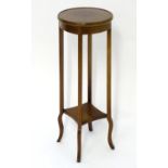 An early 20thC mahogany jardinière stand with a circular moulded top and having decorative satinwood