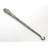 A silver handled button hook with embossed cherub / angel decoration to handle. Hallmarked