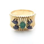 A 14ct gold dress ring set with emerald green coloured stone and four blue spinel. Ring size approx