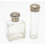 A silver lidded glass scent bottle and a matching silver lidded glass vanity bottle, both lids