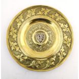 An Arts & Crafts brass charger with hammered detail, central shield with inlaid EF monogram with the