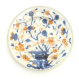 A Japanese plate in the Imari palette with hand painted decoration depicting blossoming flowers.