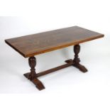 An early / mid 20thC oak dining table with a rectangular top above two cup and cover