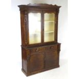A 19thC scumbled pine bookcase with a moulded cornice above two glazed doors flanked by corbels