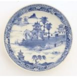 A Chinese blue and white dish / bowl with hand painted decoration depicting a landscape with