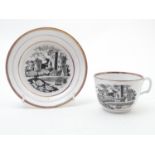A 19thC tea cup and saucer with monochrome transfer decoration depicting a river landscape with a