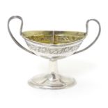 A Continental silver two section open salt and pepper of urn form, with gilded two section interior.