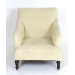 An early 20thC chair with crème upholstery and raised on turned tapering front legs and squared back