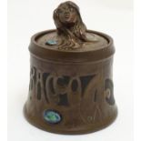 A Bretby Art Nouveau tobacco pot with faux hammered copper effect and enamelled cabochon detail. The