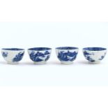 Four blue and white Caughley style tea bowls decorated with landscape scenes with pagodas and