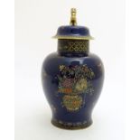 A Wiltshaw and Robinson Carlton Ware baluster vase and cover decorated with flowers, with a blue
