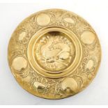 An Arts Nouveau brass charger with hammered detail, the central section with embossed stylised