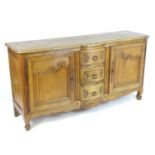 A late 19thC / early 20thC cherry wood sideboard with a bowed breakfront above three short drawers