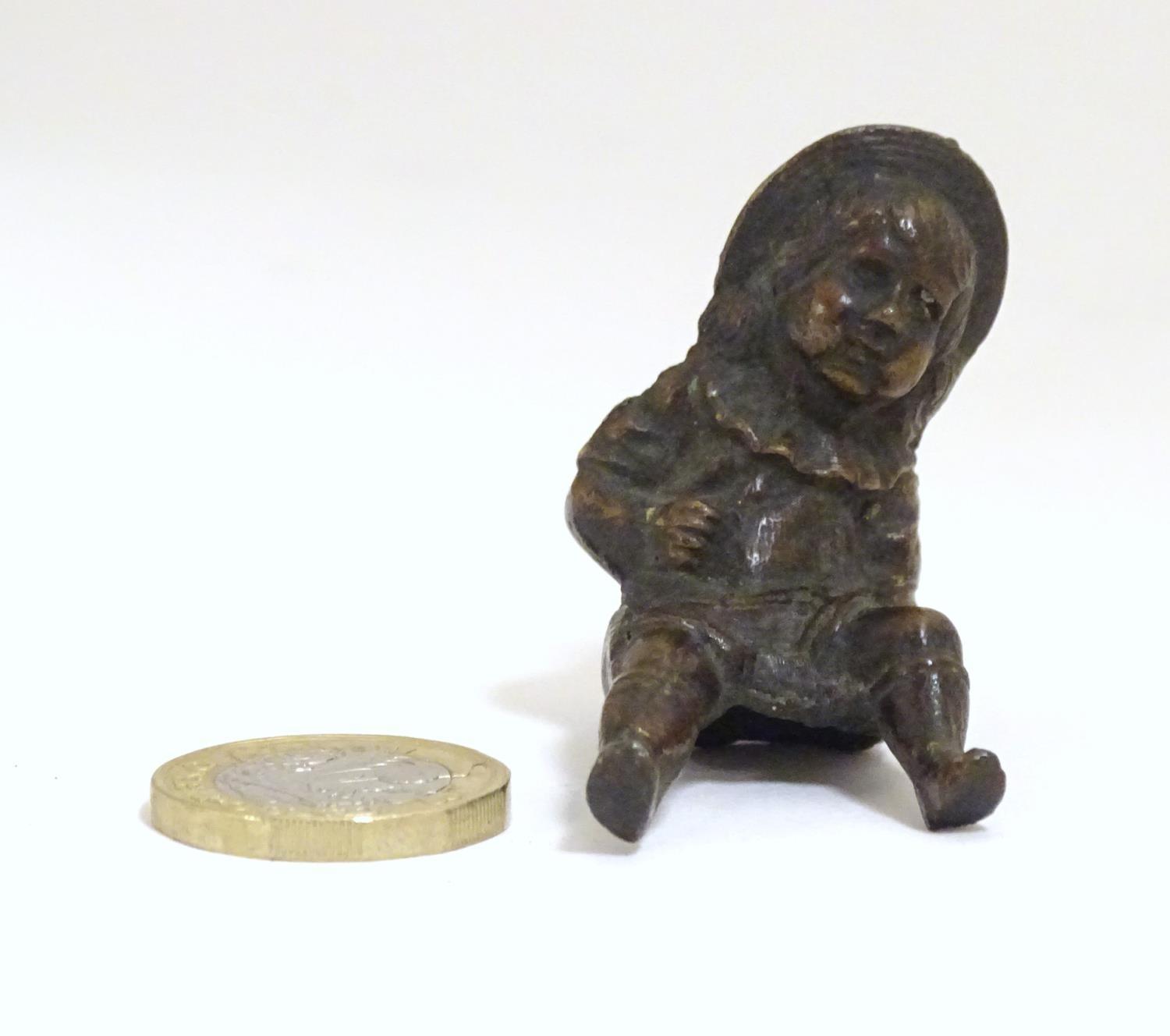 A late 19thC bronze modelled as a young girl with a hat. Approx. 2" Please Note - we do not make