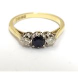 An 18ct ring set with dark blue spinel flanked by diamonds. Ring size approx I Please Note - we do