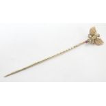 A 9ct gold stick pin surmounted by an eagle / bird and ruby 3 1/2" high Please Note - we do not make