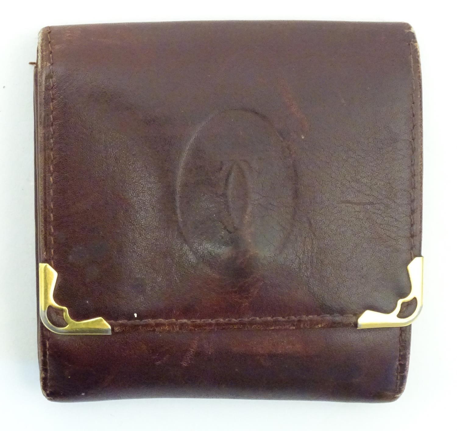 A Cartier small leather wallet / coin purse. Approx. 3 1/4" Please Note - we do not make reference