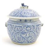 A Chinese blue and white pot and cover with scrolling floral and foliate detail. The lid