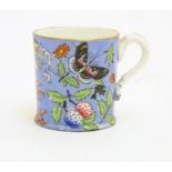 A 19thC coffee cup with hand painted decoration depicting butterflies, strawberries and foliage.