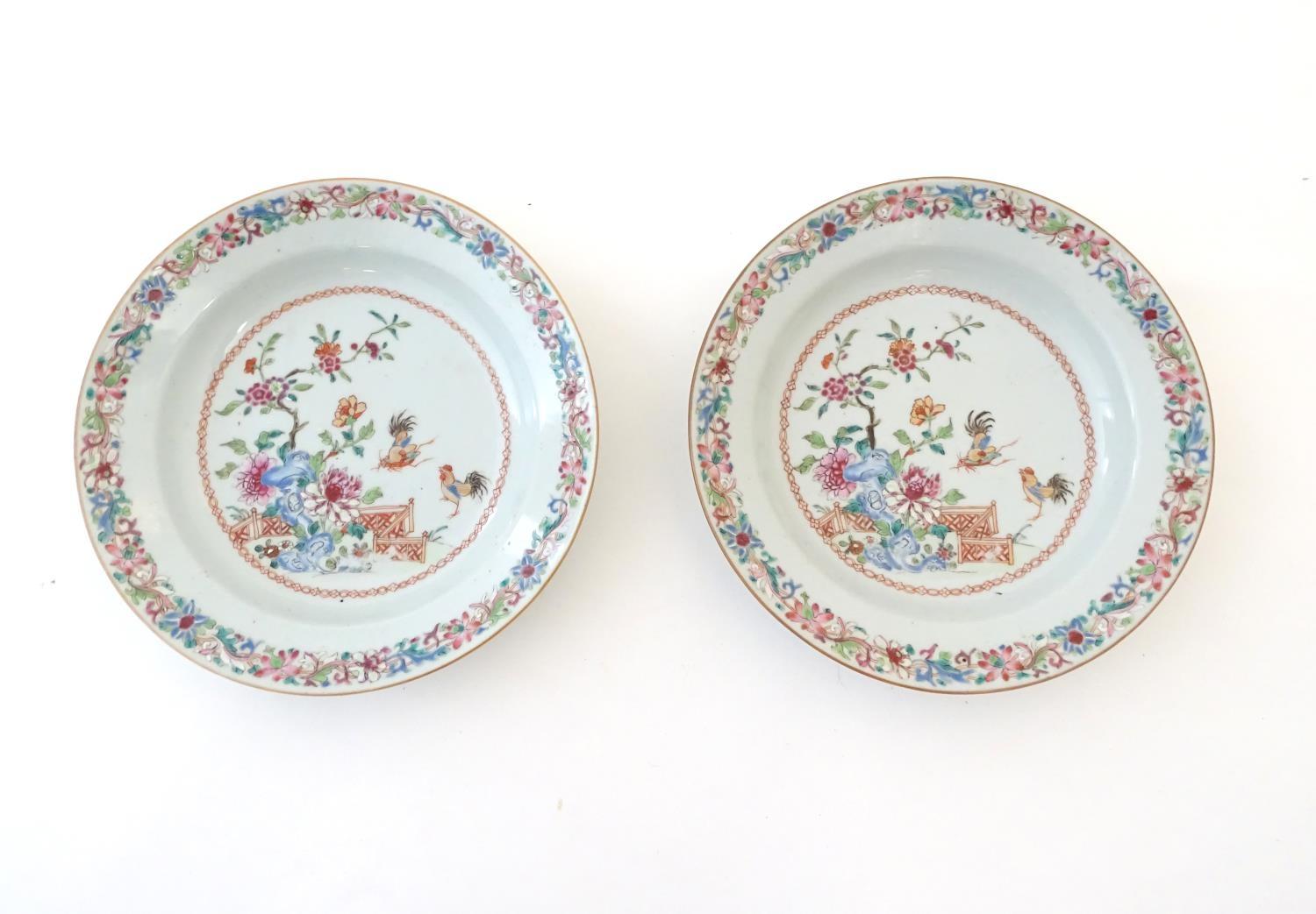 A pair of Chinese dishes decorated with a garden / terrace scene with flowers and foliate with two