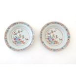 A pair of Chinese dishes decorated with a garden / terrace scene with flowers and foliate with two