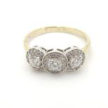 An 18ct gold ring set with tri of diamonds bordered by further diamonds. The ring size approx M 1/