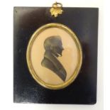 A 19thC oval watercolour silhouette portrait miniature of a man with gilt highlights. Approx. 5 3/4"