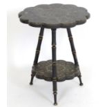 A late 19thC Kashmiri table with a shaped top supported by three turned supports and having a