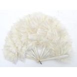 An early 20thC white feather fan with 9 white painted wooden sticks with floral and foliate