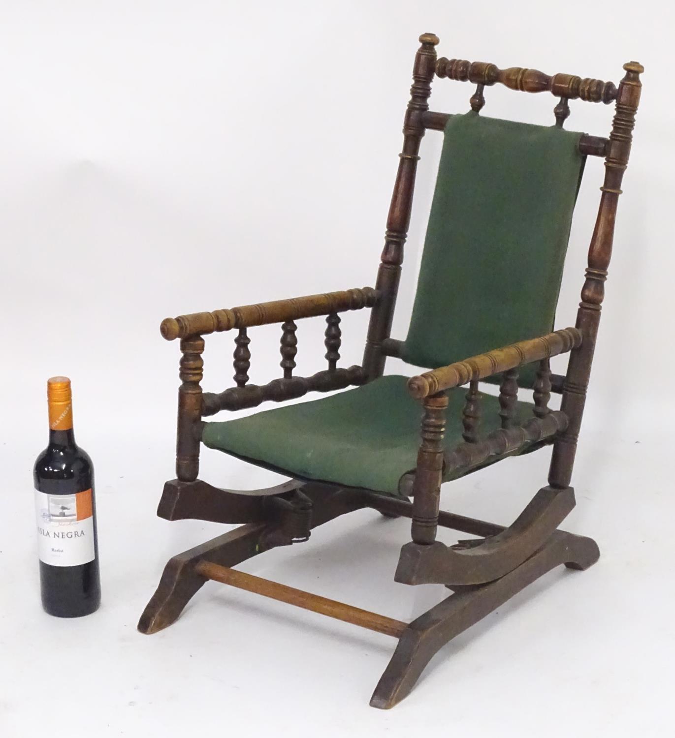 An early 20thC childs rocking chair with a ring turned frame above a cloth seat and turned spindle - Image 4 of 4