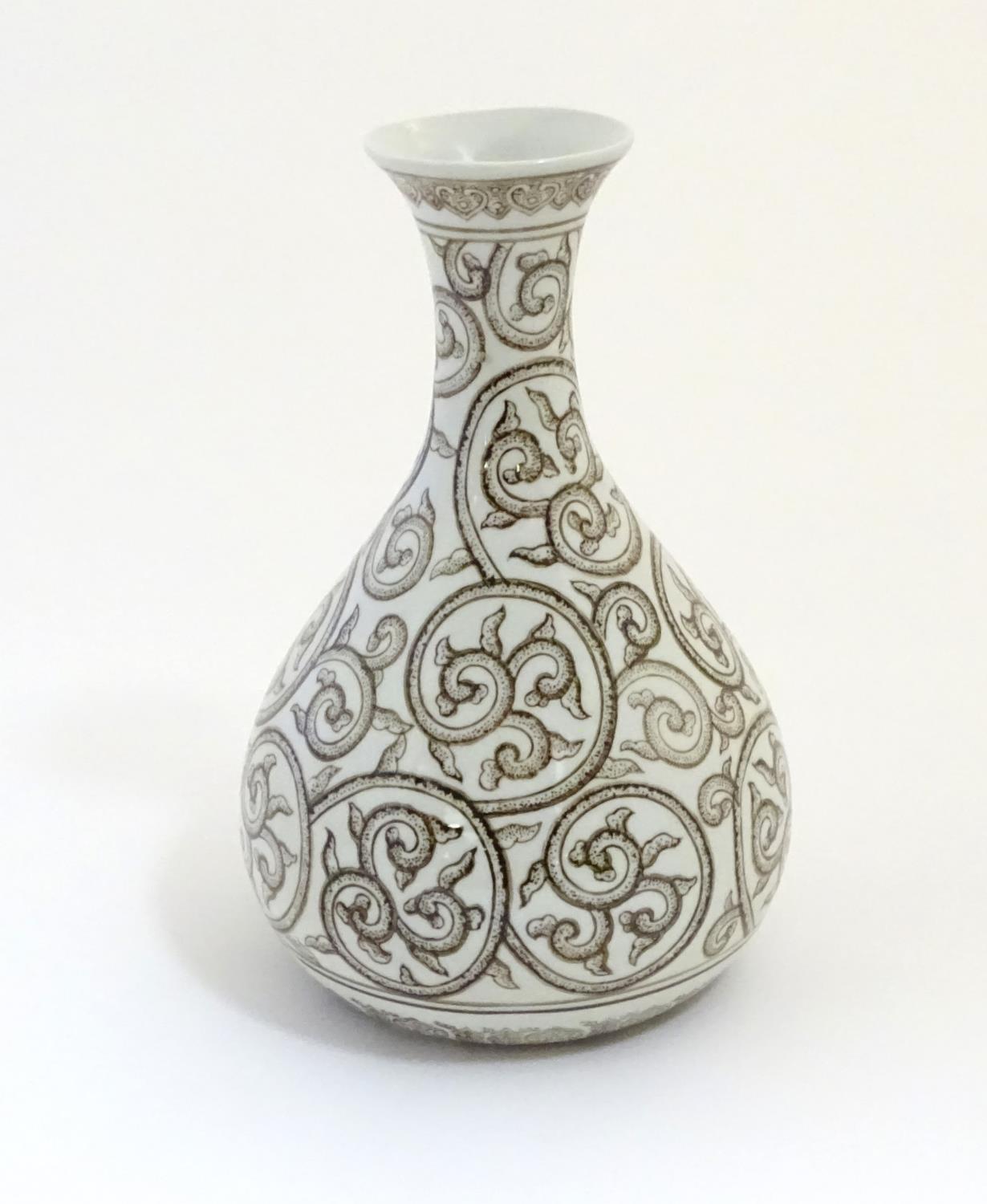 A Chinese baluster vase with a flared rim decorated with stylised scrolling foliage with dotwork