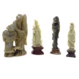 Four Oriental soapstone carvings to include a figural group depicting an elder / scholar with