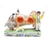 A Victorian Staffordshire bull baiting figural group, depicting a bull fight with two dogs and a