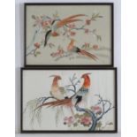 Two oriental silk embroideries depicting stylised golden pheasant birds perched on branches, with
