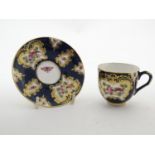 A Royal Worcester tea cup and saucer decorated blue scale ground and vignette panels hand painted