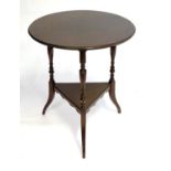 An Aesthetic movement mahogany table with a circular top above three turned supports and splayed