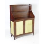 A Regency mahogany side cabinet of concave form, having a waterfall style bookcase with two