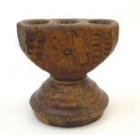 A 19thC Indian carved wooden candle holder with floral decoration, formerly a seed spreader. Approx.