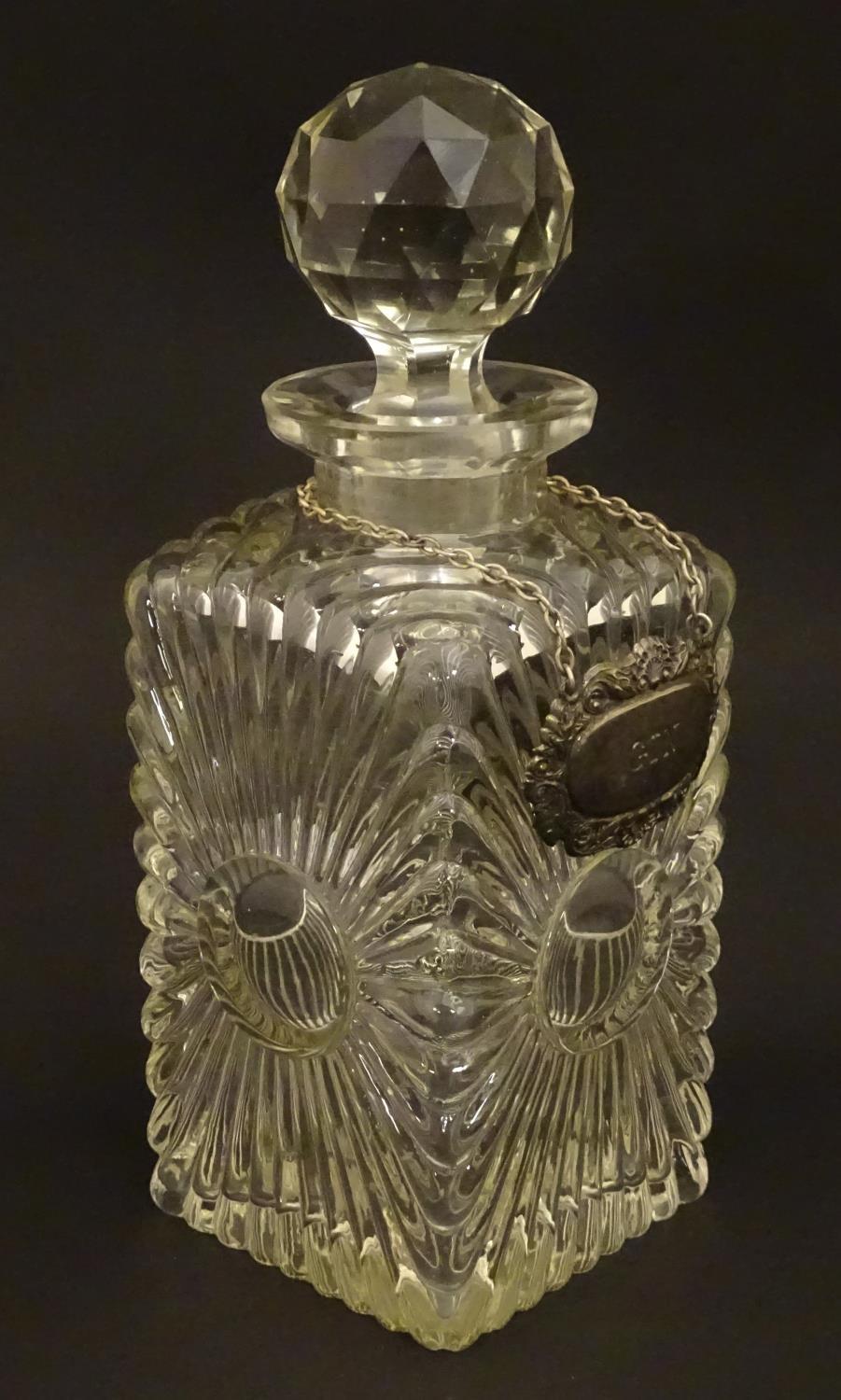 An early 20thC glass decanter of squared form. Together with a silver plate wine label / bottle