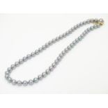 A Majorica simulated grey pearl necklace with gilt metal clasp and safety chain, both stamped 925.