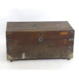 A 19thC camphor wood brass bound trunk flanked by wrought iron carrying handles and raised on