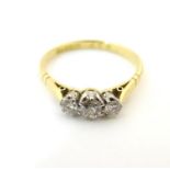 An 18ct gold ring set with a trio of platinum set diamonds to top. Ring size approx. size K Please