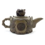 A Chinese Yixing style teapot decorated with bat detail in relief, with character marks within