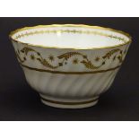 A 19thC white porcelain tea bowl with ribbed sides and gilt decoration of stylised foliage and