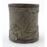 An Oriental bamboo brush pot, the body with carved decoration depicting a seated scholar in a