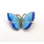A silver brooch formed as a butterfly with blue guilloche enamel decoration 1" wide Please Note - we