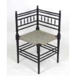 An Aesthetic movement corner chair in the manner of Morris & Co with an ebonised finish and turned