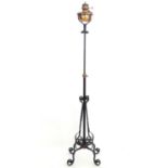 A Victorian wrought iron and copper telescopic standard lamp with burner marked ' Lampe veritas '