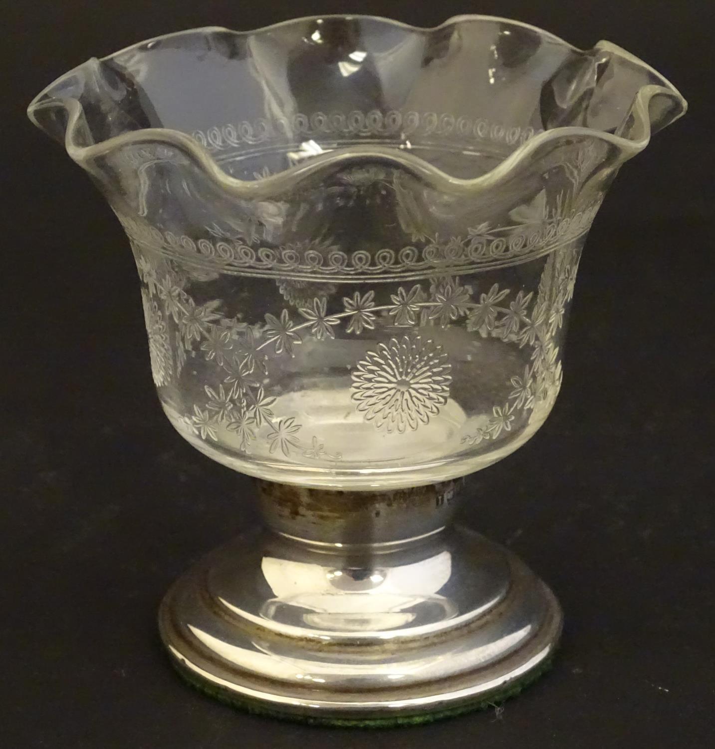 An early 20thC small glass dish with etched decoration and flared rim, on a silver pedestal base